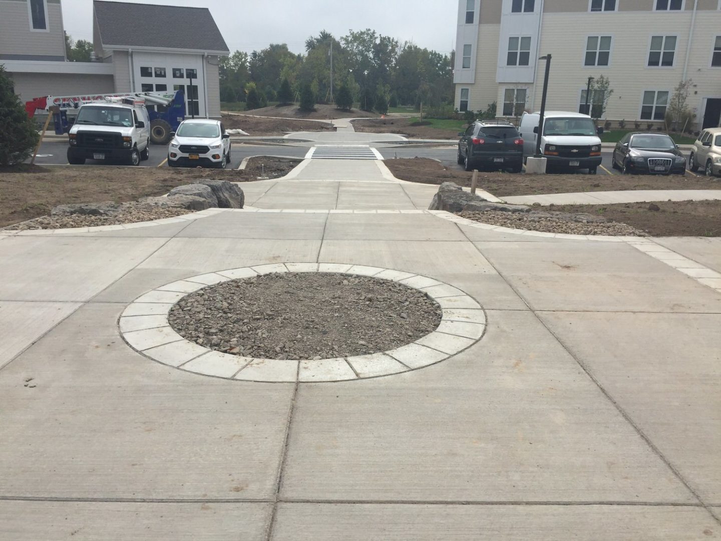 Completed concrete walkway with decorative circular detail at a residential development